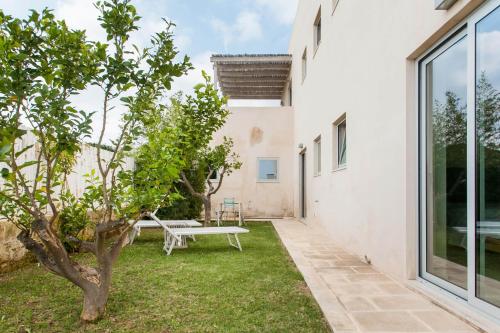 a garden with a bench and a tree at Wp Relais apartments in Diso