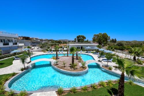 een uitzicht over een zwembad met palmbomen bij Paradise Garden in Kolimbia