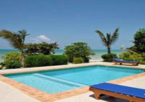 een zwembad met uitzicht op de oceaan bij Serenity Luxury Villas in Paje