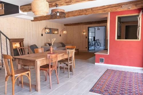 a dining room with a wooden table and chairs at La BERGERIE DE BELESTEN in Béon