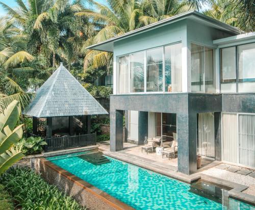 a house with a swimming pool in front of a house at Mandarin Oriental, Sanya in Sanya