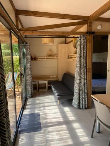 ベック・ド・モルターニュにあるChalet panoramique avec vue sur étangのソファとベッドが備わる客室です。
