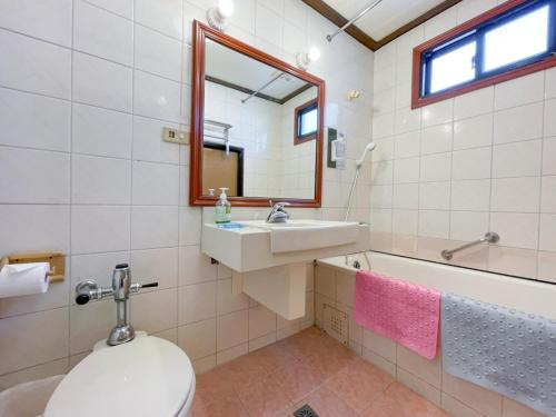 a bathroom with a toilet and a sink and a mirror at Guide Hotel Changhua Jhongjheng in Changhua City