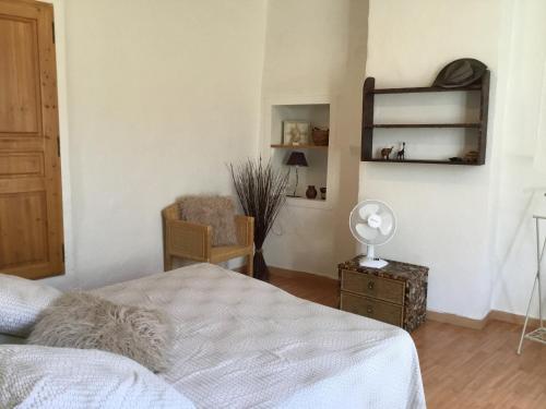 a bedroom with a bed and a desk and a chair at Agréable maison de village provençal in Volx