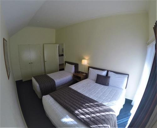 a hotel room with two beds and a window at The Peaks Motor Inn in Ohakune