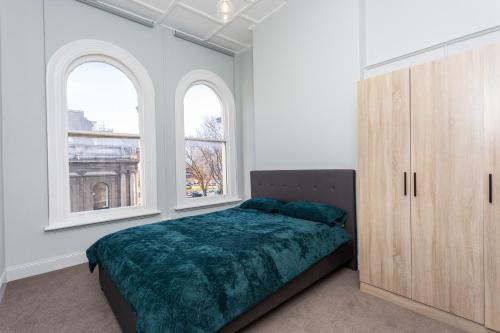 a bedroom with a bed and two windows at nap nap - Second floor in Dunedin