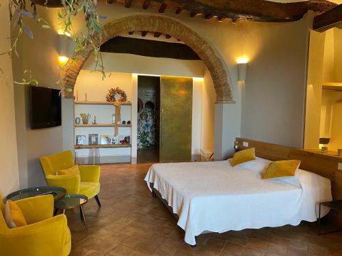 モンテプルチャーノにあるLa Corte Segretaのベッドルーム1室(ベッド1台、椅子2脚、テレビ付)