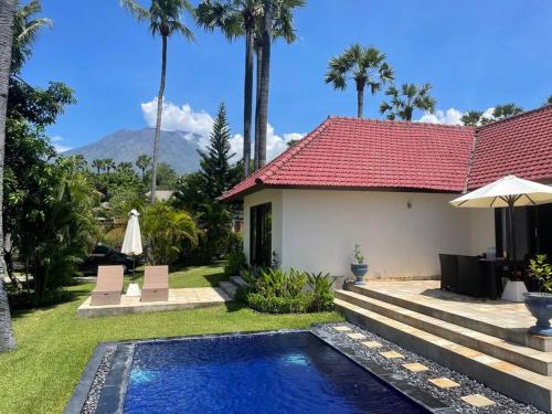 a villa with a swimming pool and a house at Serene 2 BR Villa Private Pool in Top Diving Area in Kubu
