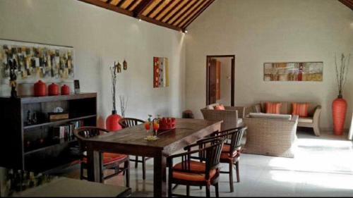 a living room with a wooden table and chairs at Serene 2 BR Villa Private Pool in Top Diving Area in Kubu