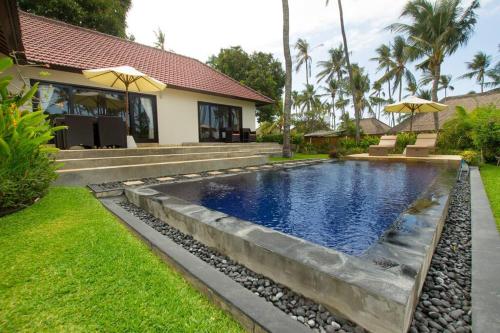 a swimming pool in the backyard of a house at Serene 2 BR Villa Private Pool in Top Diving Area in Kubu