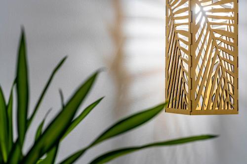 a light hanging from a wall next to a plant at ammos suites in Ierápetra