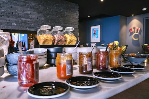 a table topped with jars of jam and bowls of food at Fahrenheit Seven Val Thorens in Val Thorens