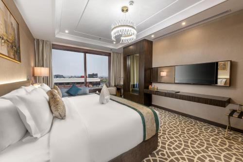 Cette chambre comprend un grand lit et une télévision. dans l'établissement Nivel Hotel, à Khamis Mushait