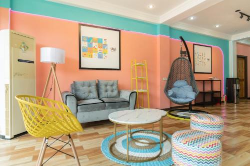 a living room with a couch and a table and chairs at Sans Hotel Beauty Palembang in Sukarami