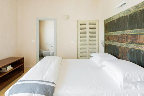 a bedroom with two white beds and a wooden headboard at Wp Relais apartments in Diso