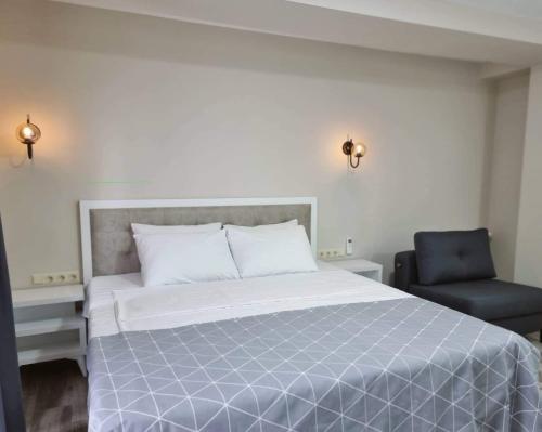 a bed and a chair in a bedroom at Picasso in Shekvetili
