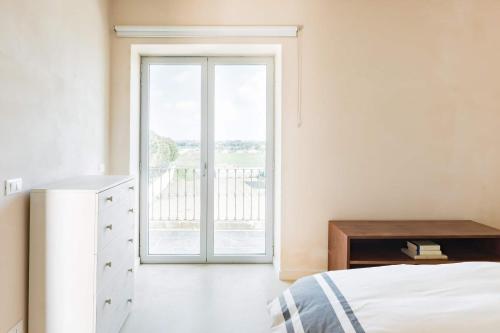 a bedroom with a bed and a sliding glass door at Wp Relais apartments in Diso