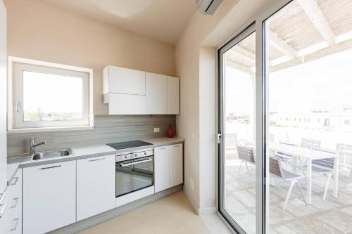 a kitchen with white cabinets and a table and a window at Wp Relais apartments in Diso