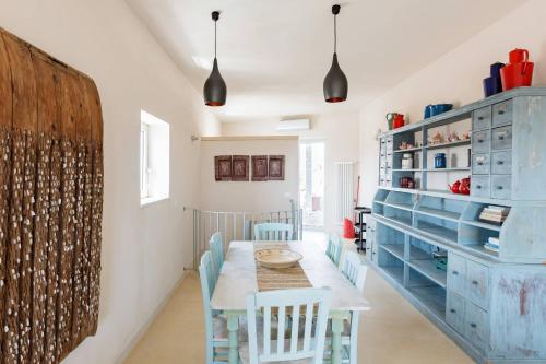 a dining room with a table and chairs and blue cabinets at Wp Relais apartments in Diso