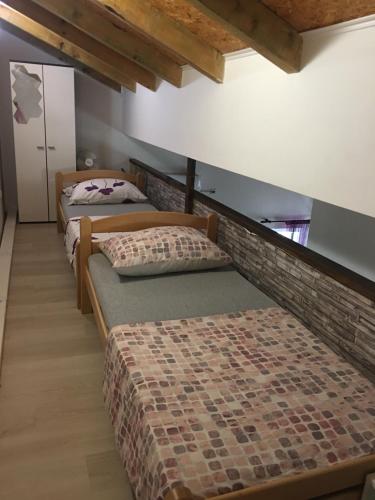 a room with three beds and a brick wall at Apartments Sun & Sea in Vodice
