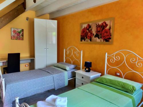 two beds in a room with orange walls at Aia Lucia B&B in Giurdignano