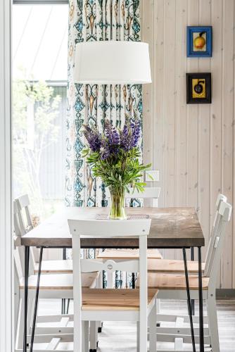 a white dining room table with a vase of flowers at Evita - 'Virš Ąžuolų' - Forest SPA - Horses - Lake in Paplatelė