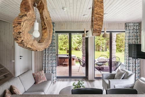 a living room with a couch and a porch at Evita - 'Virš Ąžuolų' - Forest SPA - Horses - Lake in Paplatelė