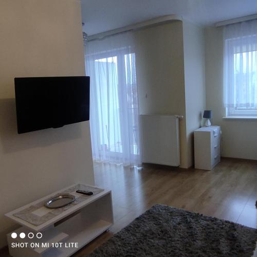 a living room with a flat screen tv on the wall at Oskar Apartament Centrum PKP in Mińsk Mazowiecki