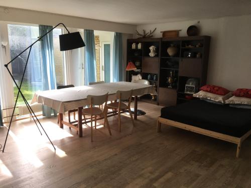 a living room with a table and a bed at Quiet villa apartment close to everything in Odense