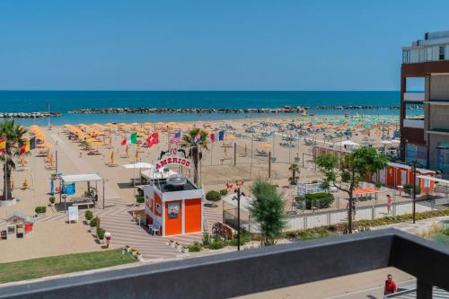 a beach with a lot of umbrellas and the ocean at Hotel Milanese in Rimini