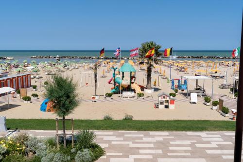 a beach with a lot of chairs and umbrellas at Hotel Milanese in Rimini