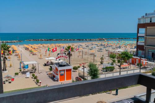 a beach with a bunch of umbrellas and the ocean at Hotel Milanese in Rimini