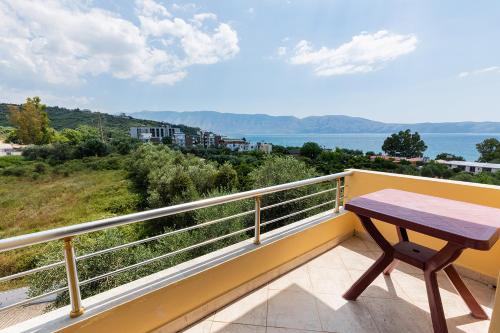 a wooden table on a balcony with a view of the water at Hotel Dini in Vlorë
