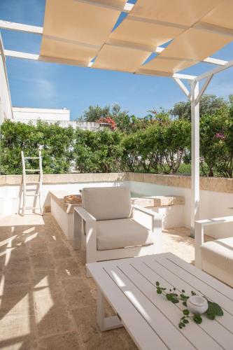 a patio with a white couch and a table at Masseria San Giovanni - Epoca Collection in Fasano