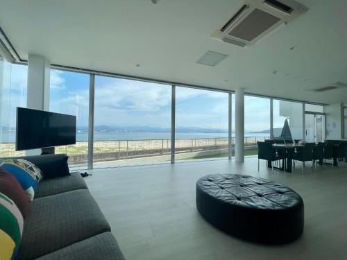 a living room with a couch and a view of the ocean at Luxury Villa Saitozaki Umihotaru in Fukuoka