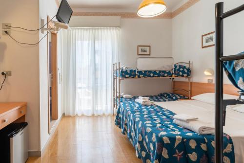 a bedroom with two bunk beds and a television at Hotel Milanese in Rimini