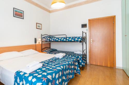 a bedroom with a bed and a bunk bed at Hotel Milanese in Rimini