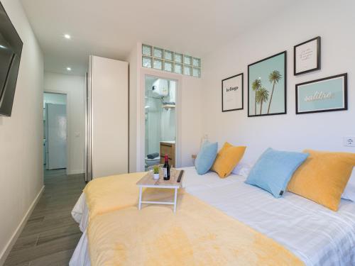 1 dormitorio con 1 cama grande con almohadas azules y naranjas en LuxuryFlats La Isleta - 2BR - Balcony - Parking - Beach, en Las Palmas de Gran Canaria