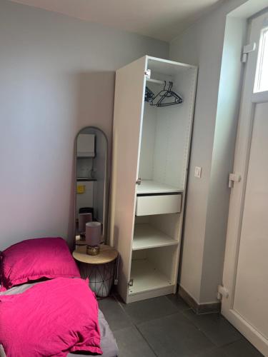 - une chambre avec un lit et un placard avec un miroir dans l'établissement Le Studio de Lucie, à Villeurbanne