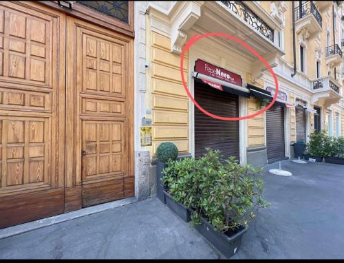 een gebouw met een grote houten deur met een rode cirkel bij B&B Liberty Suite Milan in Milaan