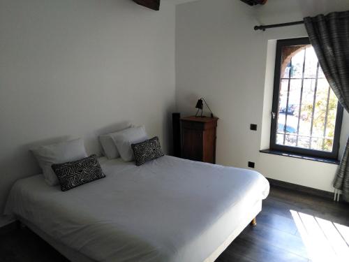 a bedroom with a white bed and a window at Hotel et Spa Le Lion d'Or in Pont-lʼÉvêque