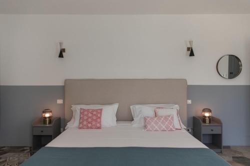 a bedroom with a large white bed with pillows at Masseria San Giovanni - Epoca Collection in Fasano