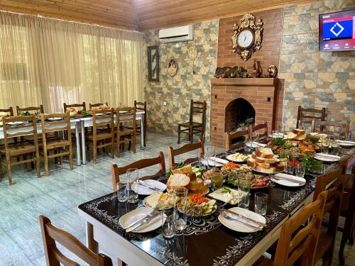 a dining room with a table with food and a fireplace at Hotel Doko in Martvili