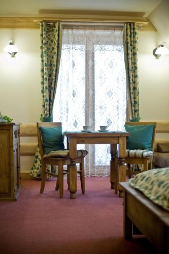 a room with a table and chairs and a window at Leśny Dworek Zakopane in Zakopane