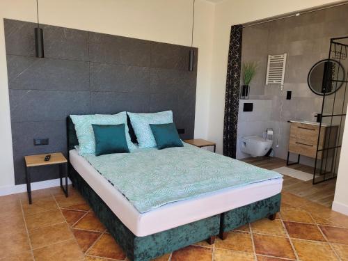 a bedroom with a large bed with blue pillows at Bed and Bread in Łeba
