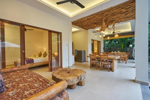 a living room with a bed and a dining room at Villa Adi in Amed