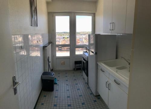 une petite cuisine avec un évier et une fenêtre dans l'établissement Appart Gare TGV vue panoramique sur la ville, au Mans