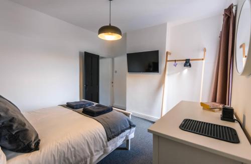 a bedroom with a bed and a desk with a keyboard at Newly refurbished Modern Stylish 2 Bedroom Cottage in Lowestoft