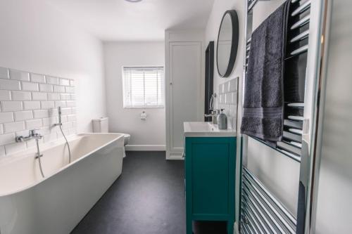 a bathroom with a tub and a sink at Newly refurbished Modern Stylish 2 Bedroom Cottage in Lowestoft