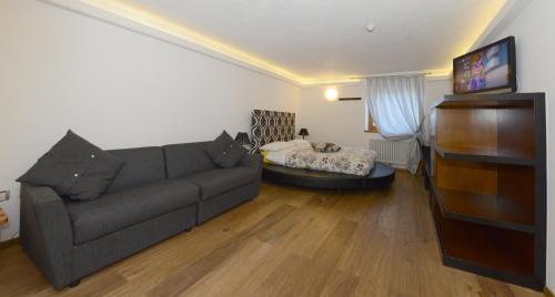 a living room with a couch and a bed at Hotel Sole in Passo del Tonale